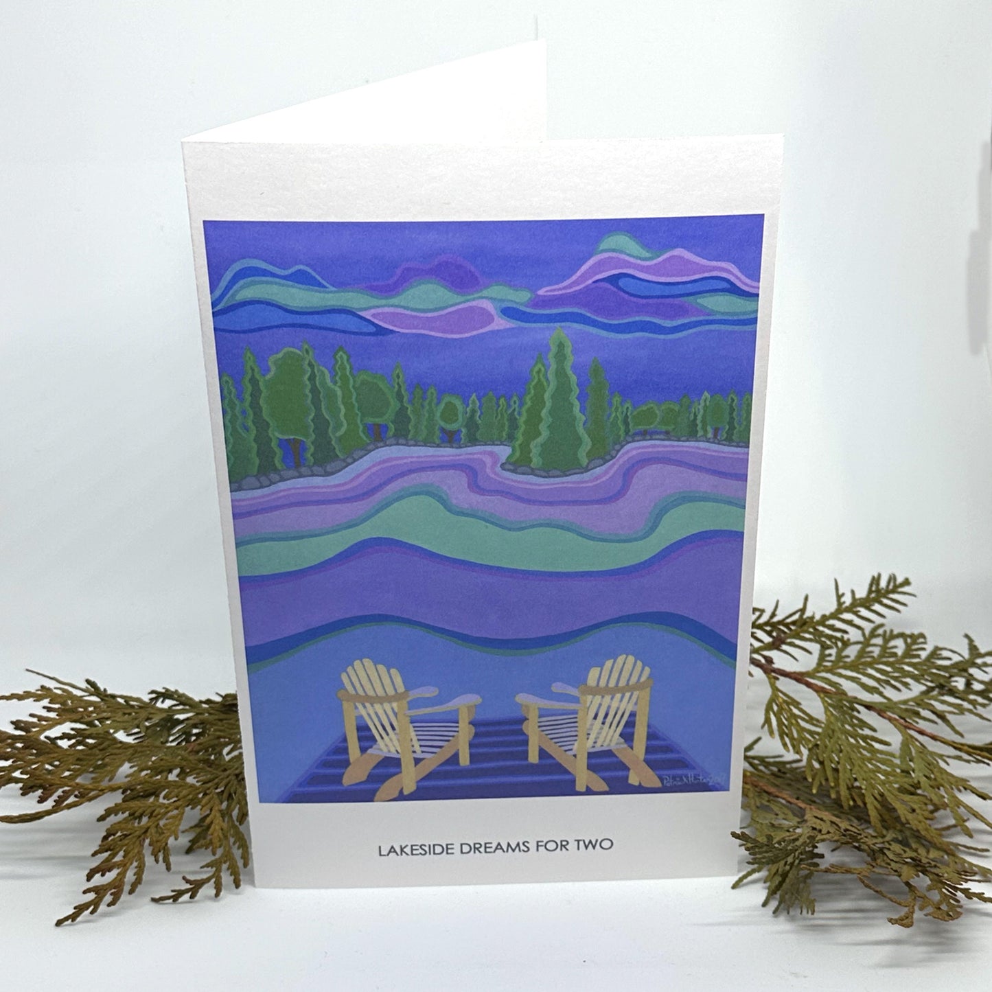 Patrick Hunter's painting, Lakeside Dreams for Two, as a greeting card standing open framed by cedar boughs.